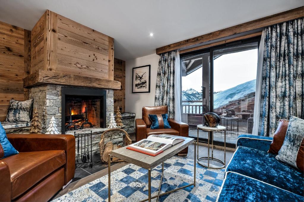 un salon avec un canapé et une cheminée dans l'établissement Hôtel La Sivolière, à Courchevel