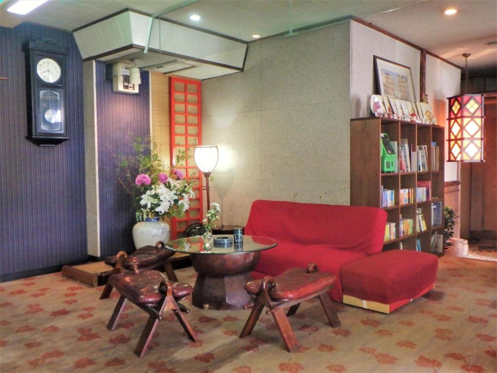 un salon avec un canapé rouge et une table dans l'établissement Kaigetsu, à Toba