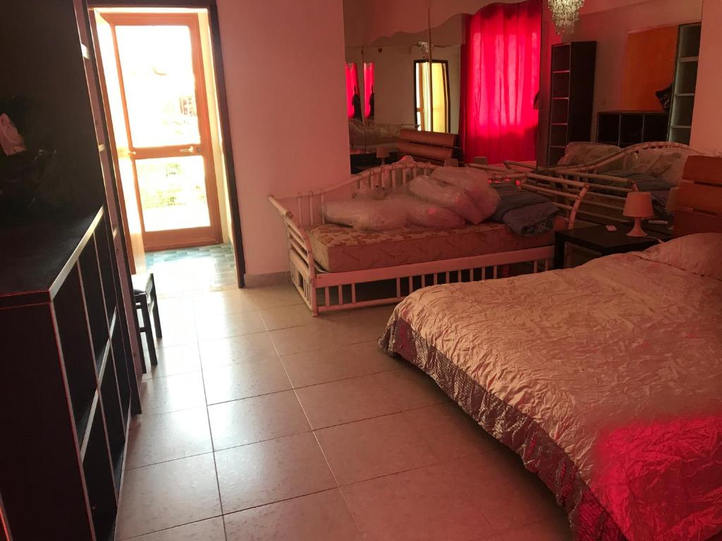 une chambre avec un lit et une fenêtre avec des rideaux rouges dans l'établissement Villa belvedere mini appartamento, à Pontecagnano