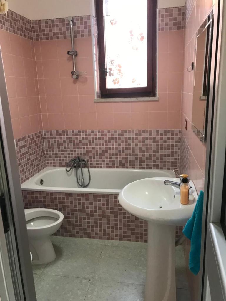 une salle de bains avec lavabo, baignoire et toilettes dans l'établissement Villa belvedere mini appartamento, à Pontecagnano 19 autres photos