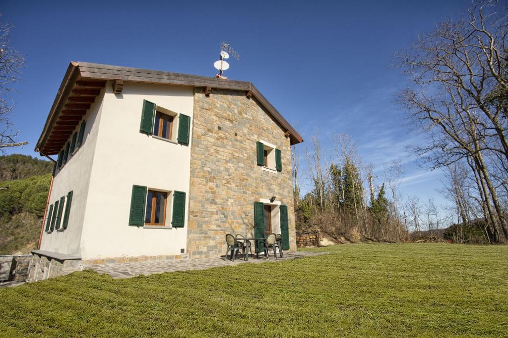 un petit bâtiment en pierre avec une table dans un champ dans l'établissement Villa Viktoria & Andras, à Tredozio