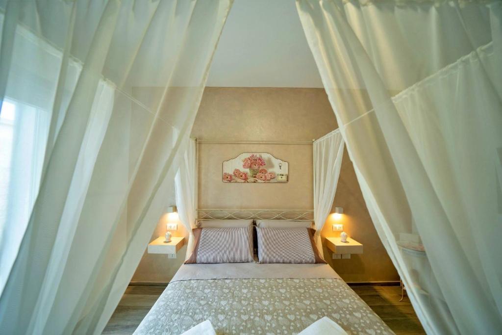 Ce lit se trouve dans un dortoir doté de rideaux blancs. dans l'établissement Villa Gargasole con Piscina privata nel Salento, à Alessano