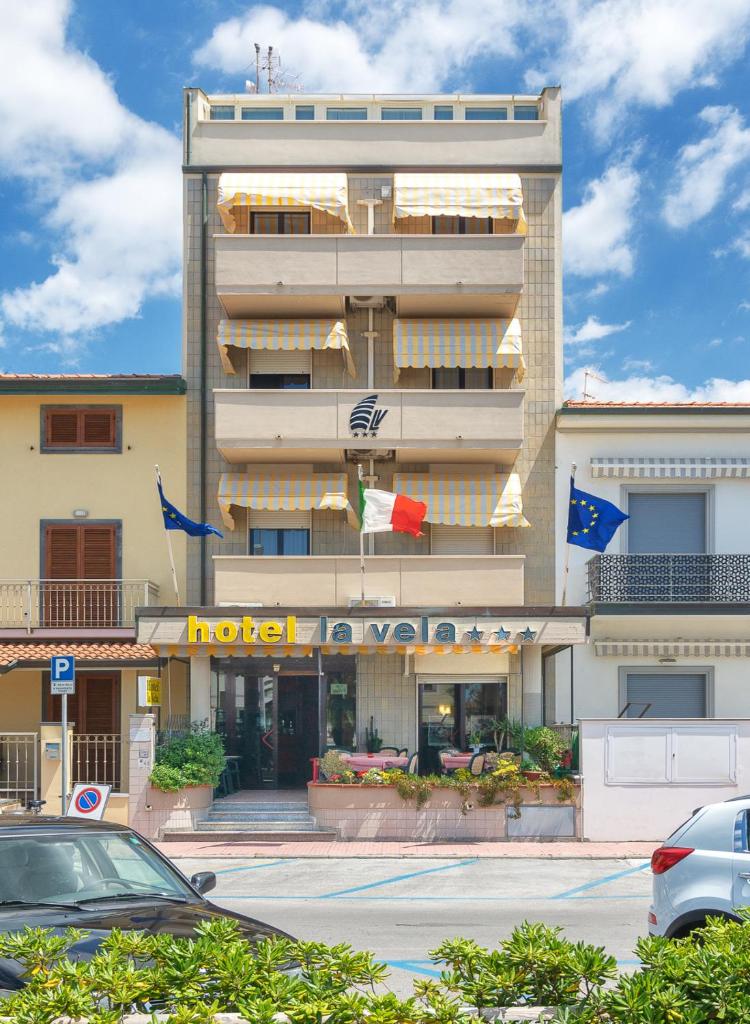 un hôtel avec une voiture garée devant dans l'établissement Hotel La Vela, à Lido di Camaiore