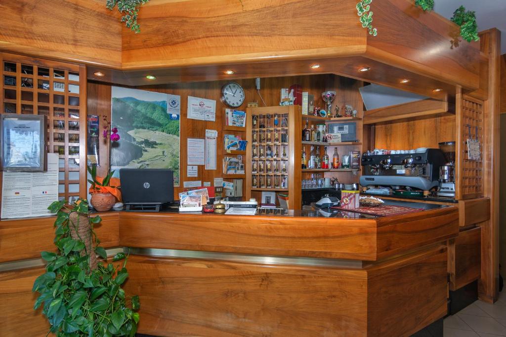 un comptoir en bois dans un magasin avec un ordinateur dans l'établissement Hotel La Vela, à Lido di Camaiore 41 autres photos