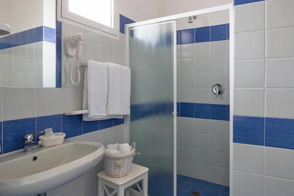 La salle de bains bleue et blanche est pourvue d'un lavabo et d'une douche. dans l'établissement Hotel Villa Maria, à Ischia 90 autres photos