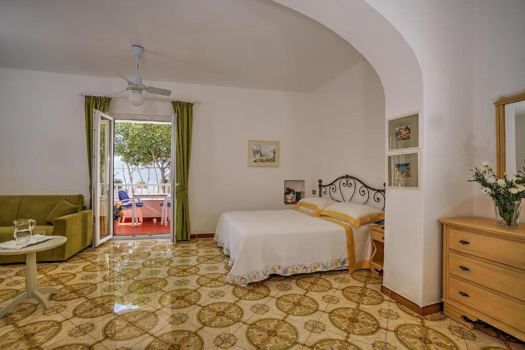 une chambre avec un lit et un salon dans l'établissement Hotel Villa Maria, à Ischia
