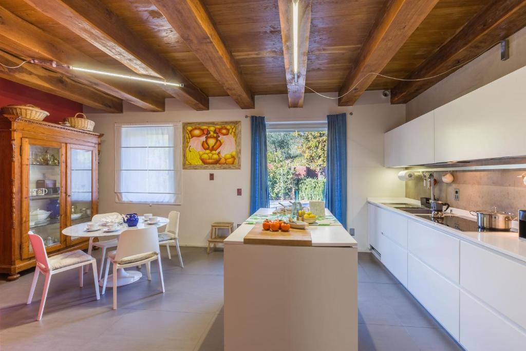 une cuisine avec des armoires blanches et une table avec des chaises dans l'établissement Villa Aurora, à Trecastelli