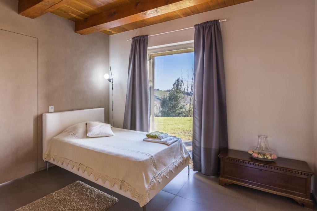 une chambre avec un lit et une grande fenêtre dans l'établissement Villa Aurora, à Trecastelli 32 autres photos