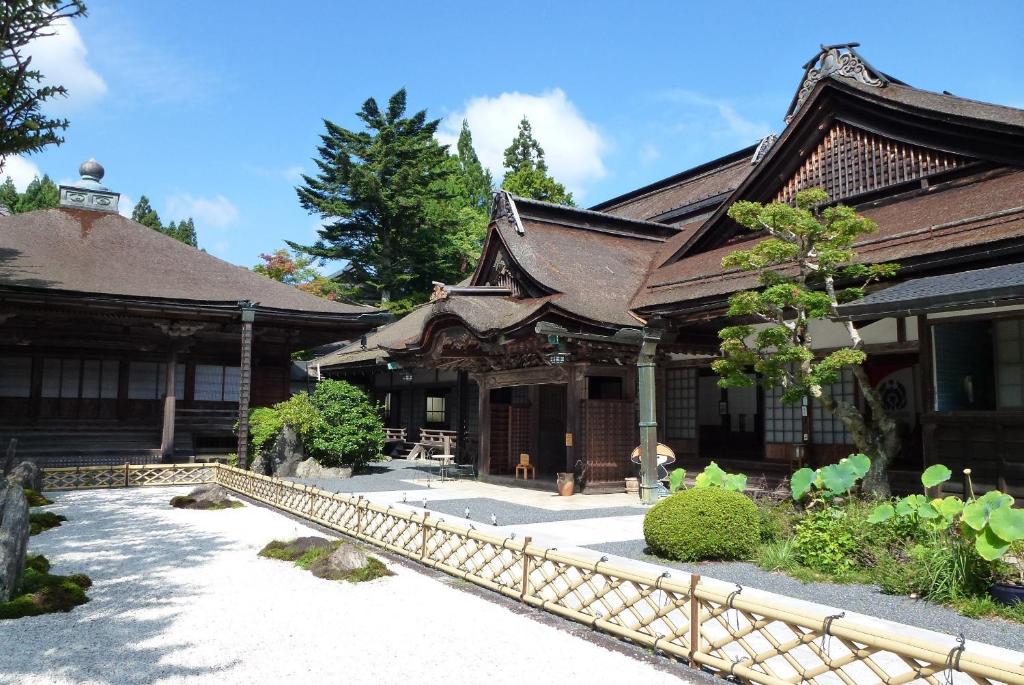 un vieux bâtiment avec une clôture devant lui dans l'établissement Koyasan Shukubo Yochiin, à Koyasan