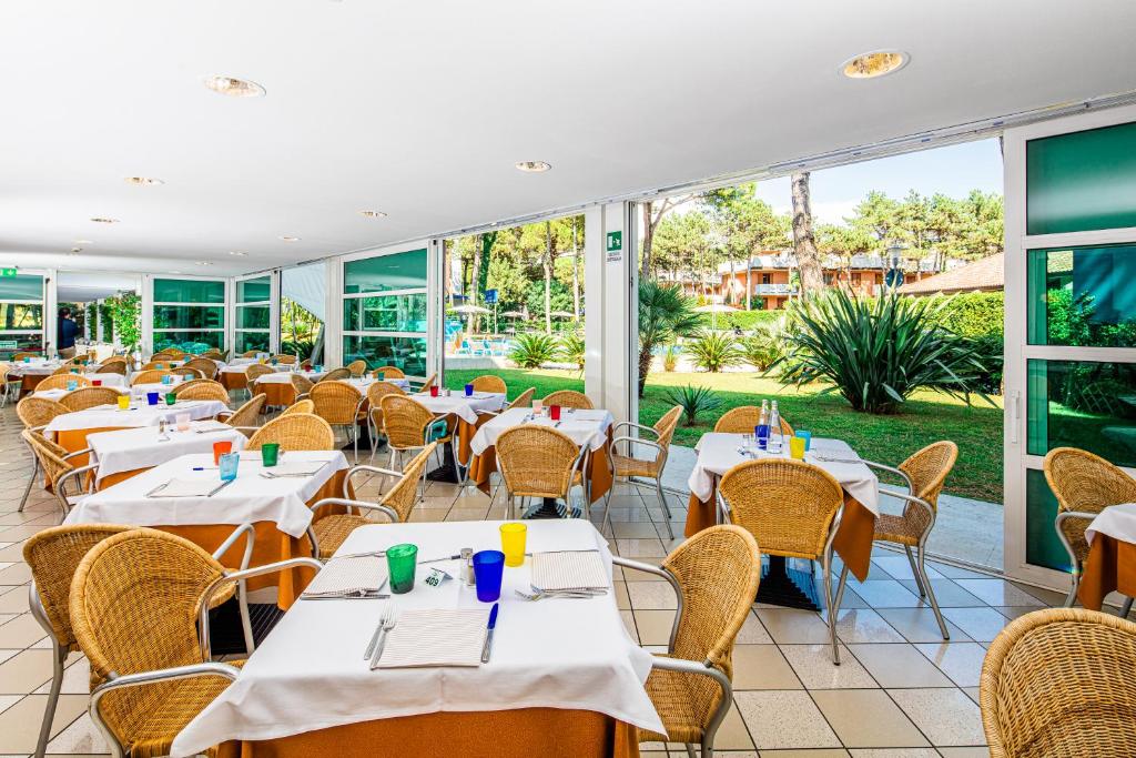 un restaurant vide avec des tables et des chaises dans l'établissement Hotel Mediterraneo, à Lignano Sabbiadoro