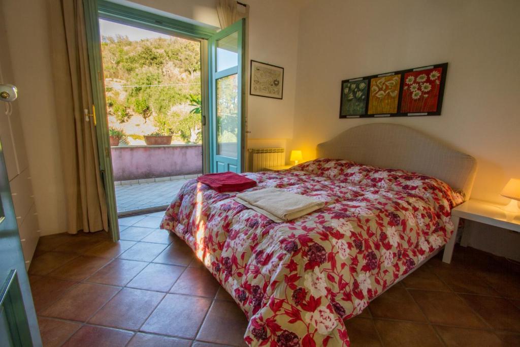 une chambre avec un lit avec une couette rouge dans l'établissement Villa Laura, à Capo dʼOrlando