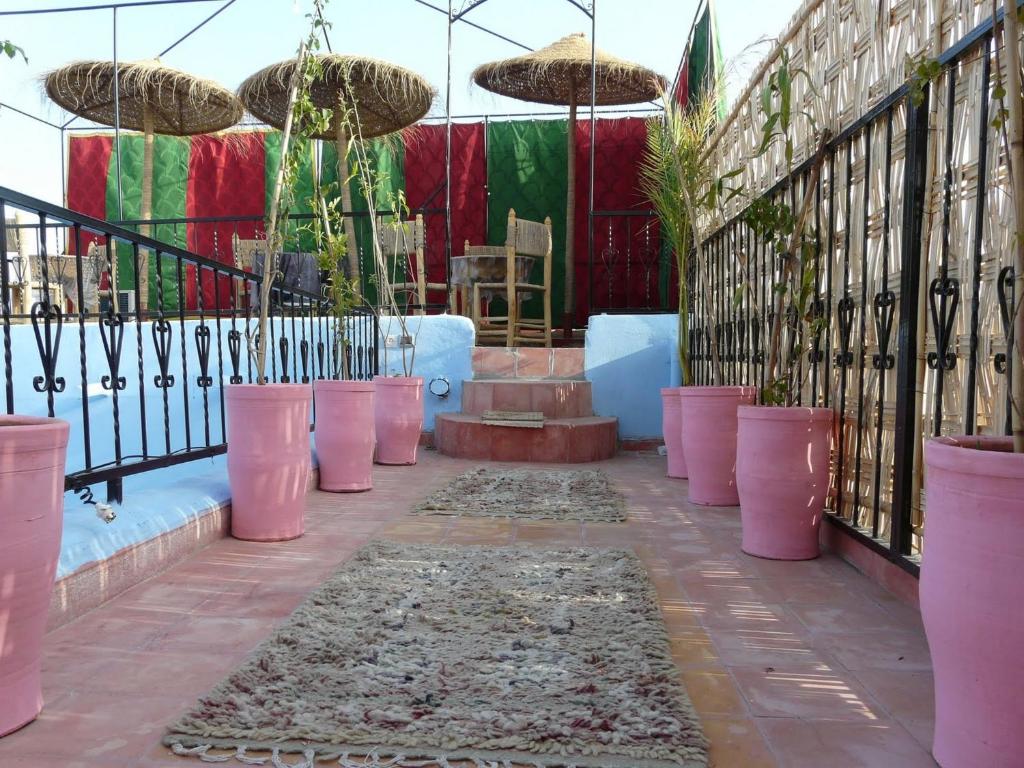 une terrasse avec des plantes en pot rose et une clôture dans l'établissement Riad Tarik, à Marrakech