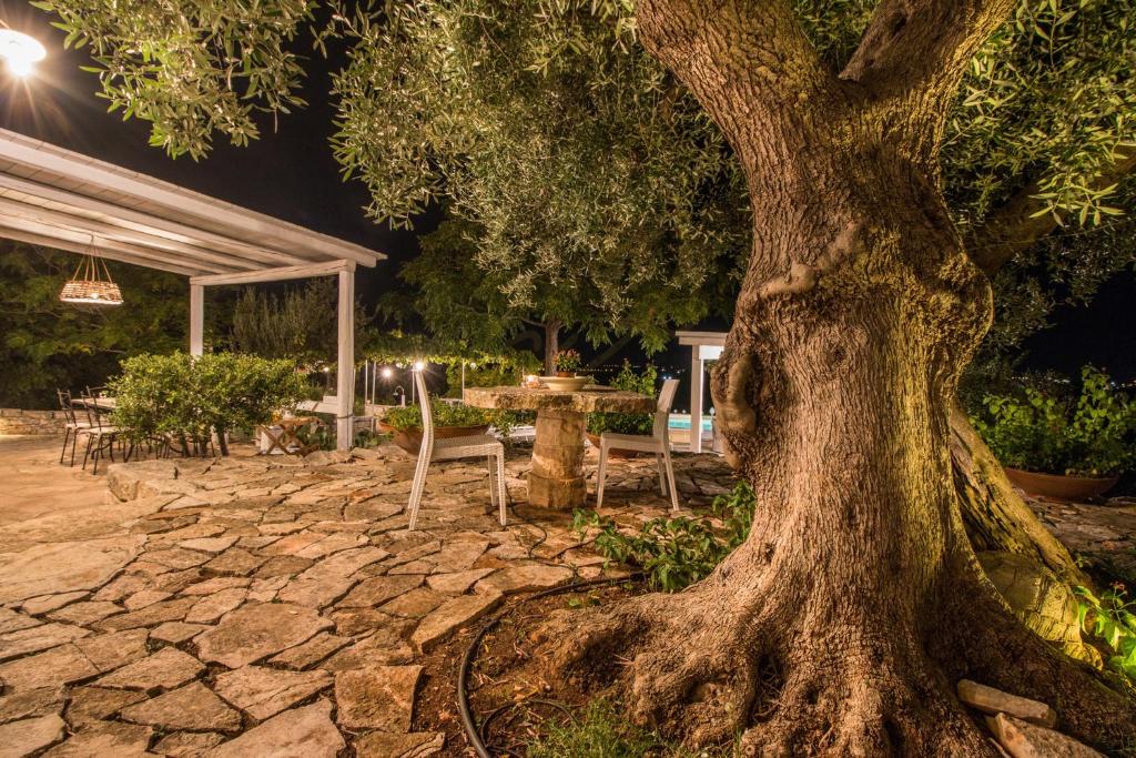 un arbre dans une cour avec une table et des chaises dans l'établissement TD Casa Torchiano Hilltop Pool with Sea View, à Monopoli