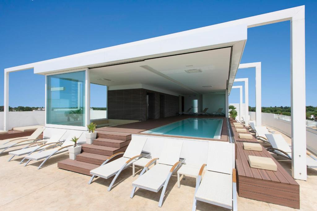 une maison avec une piscine et des chaises longues dans l'établissement Il Teatro, à Lido di Jesolo