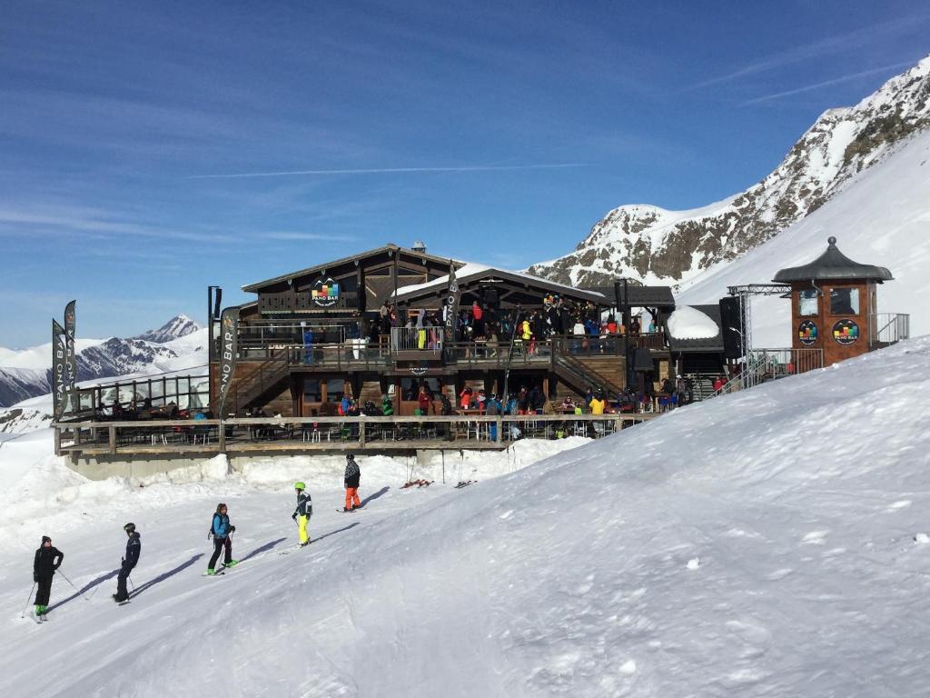 - un groupe de personnes skier devant un lodge de ski dans l'établissement Studio Kandahar - Les 2 Alpes, à Les Deux Alpes