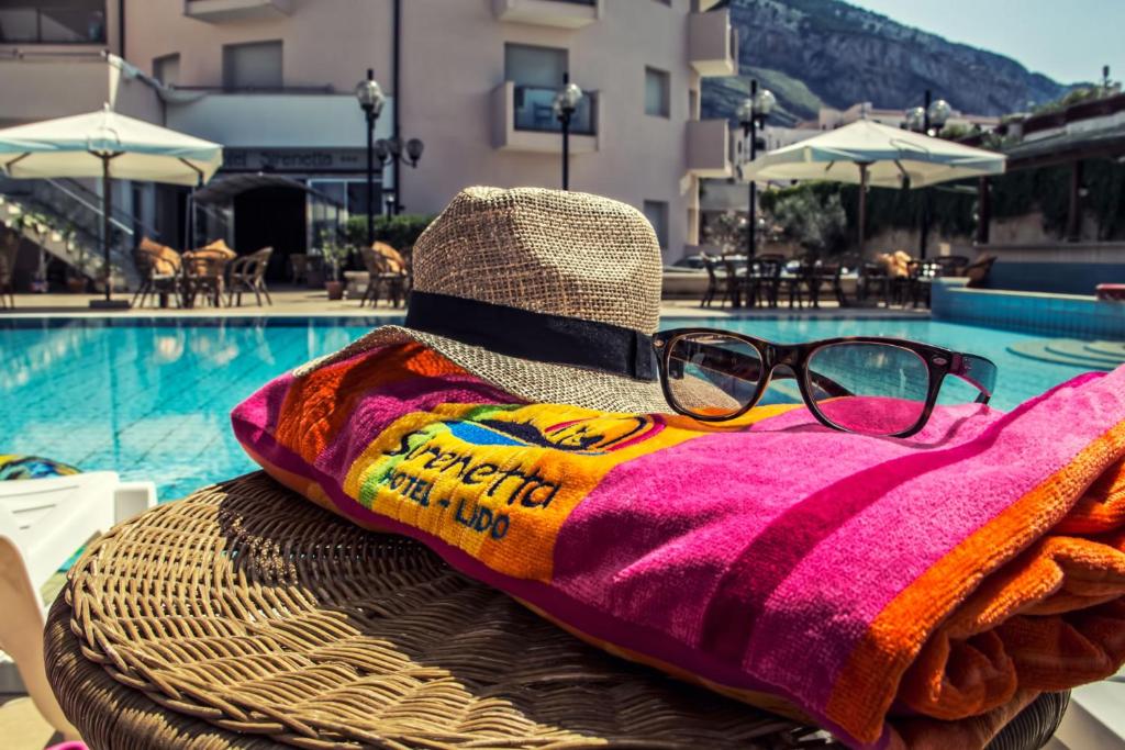 - une paire de lunettes assise sur une serviette à côté de la piscine dans l'établissement Hotel Sirenetta, à Isola delle Femmine