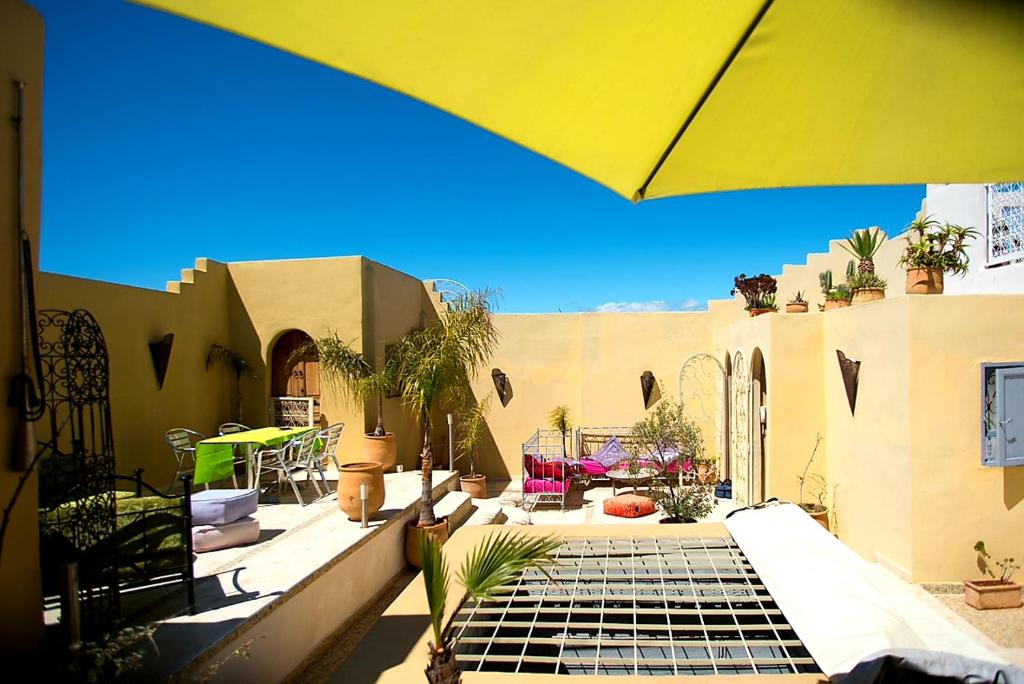 une maison avec une terrasse dotée d'un parasol jaune dans l'établissement Riad Safir, à Meknès