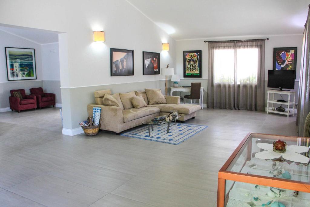 un salon avec un canapé et une table dans l'établissement Albaruja Hotel, à Costa Rei