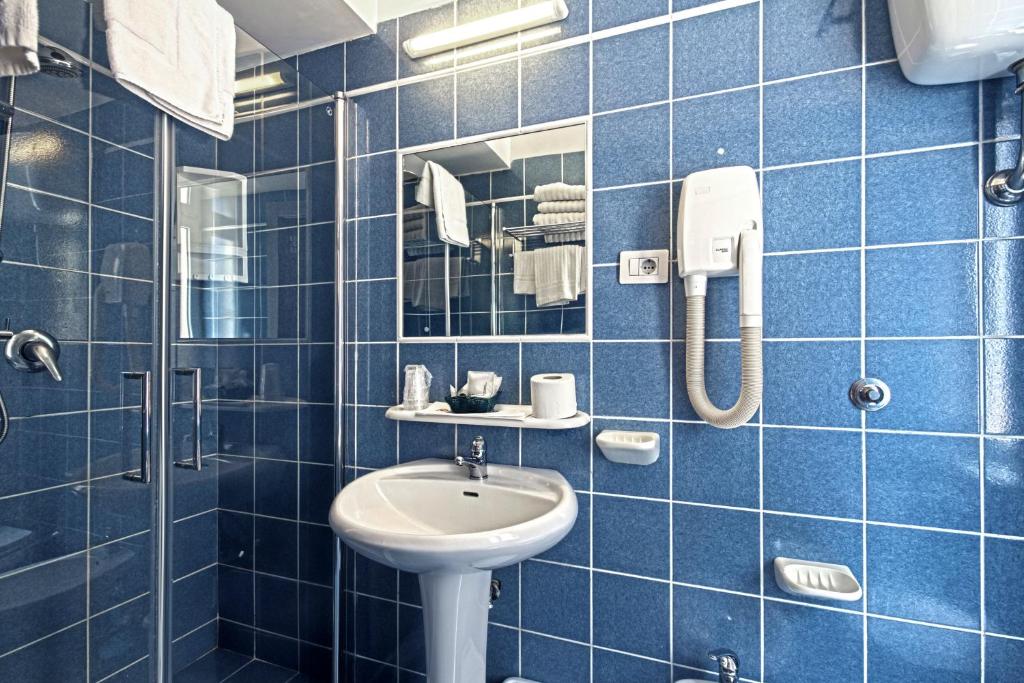 une salle de bain carrelée bleue avec un lavabo et une douche dans l'établissement Hotel La Scaletta, à Lido di Ostia 89 autres photos