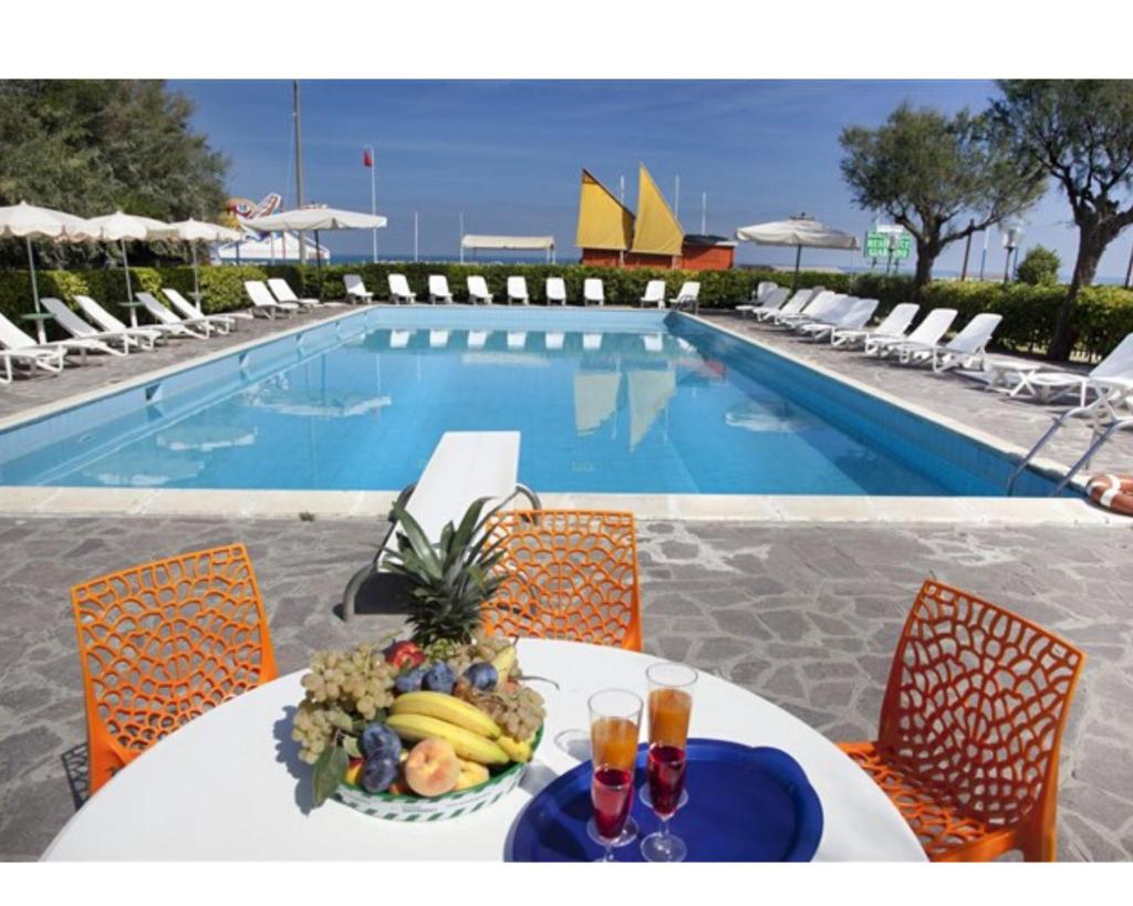 - une table avec des fruits à côté de la piscine dans l'établissement Hotel Residenza Giardino, à Bellaria-Igea Marina