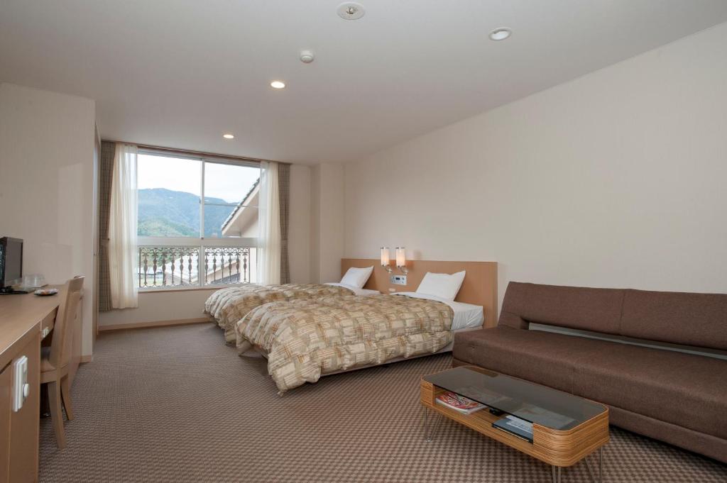 une chambre d'hôtel avec un lit et un canapé dans l'établissement The Gran Resort Kinosaki, à Toyooka
