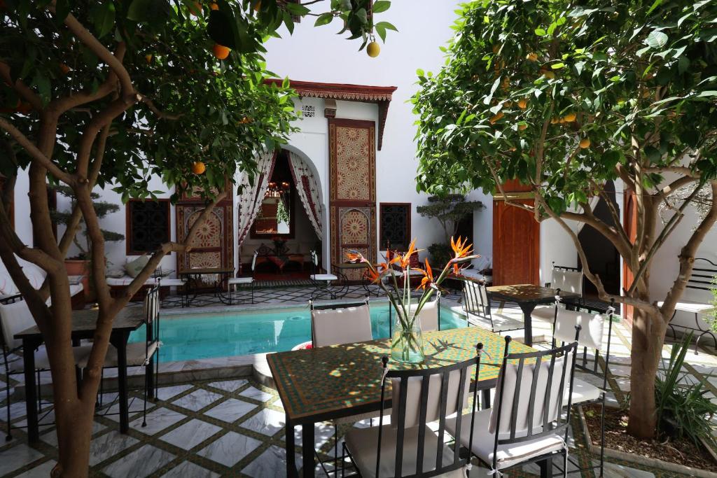 un patio avec une table et des chaises à côté d'une piscine dans l'établissement Riad Zineb, à Marrakech