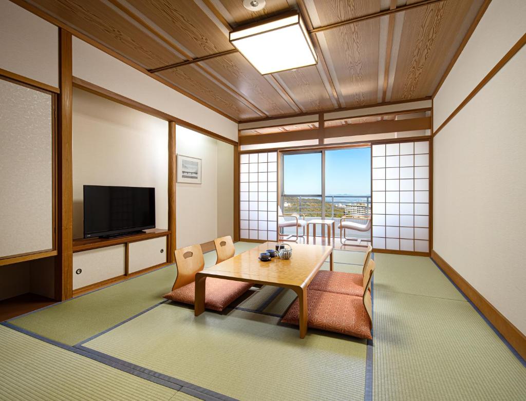 un salon avec une table et une télévision dans l'établissement The Gran Resort Princess Arima, à Kobe