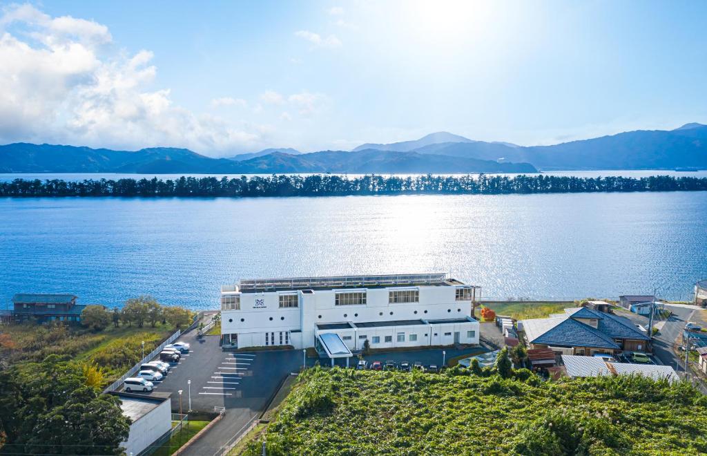 une vue aérienne d'un bâtiment à côté d'une masse d'eau dans l'établissement The Gran Resort Amanohashidate, à Miyazu