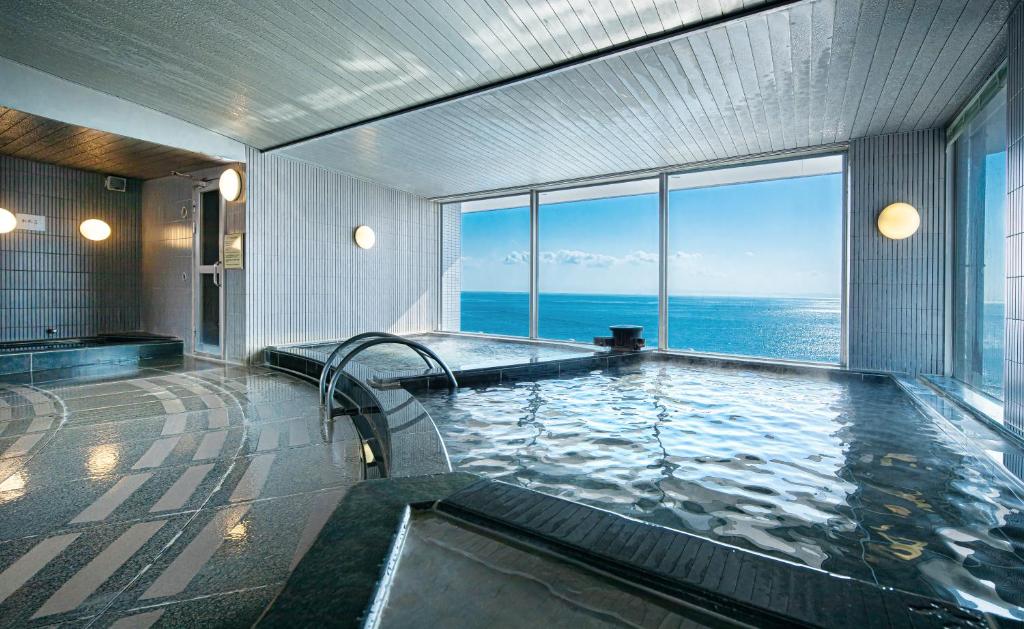 - une salle de bains avec une piscine offrant une vue sur l'océan dans l'établissement The Gran Resort Elegante Awajishima, à Awaji
