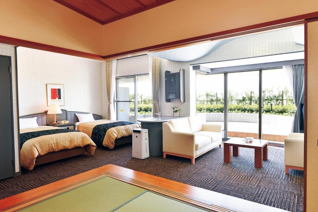 une chambre d'hôtel avec deux lits et un salon dans l'établissement The Gran Resort Princess Arima, à Kobe
