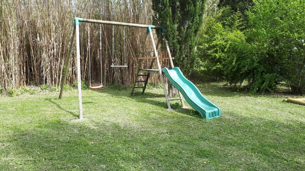 une aire de jeux avec un toboggan dans une cour dans l'établissement gite dentelles, à Loriol-du-Comtat