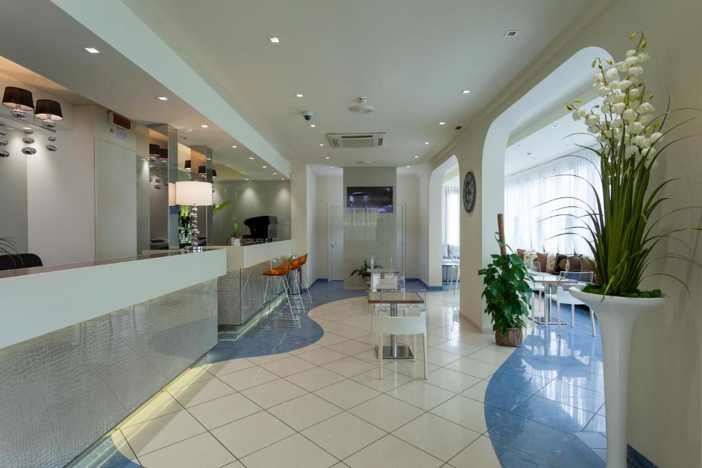 - un hall avec un bar doté de tables et de chaises dans l'établissement Hotel Aurora Mare, à Rimini