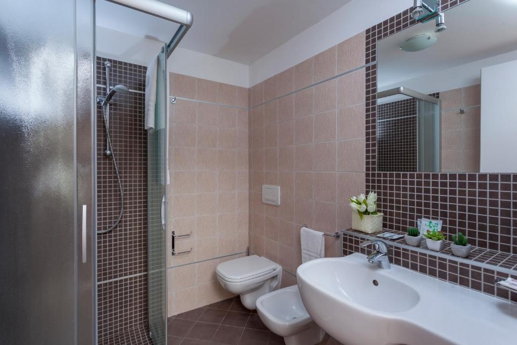une salle de bain avec un lavabo, des toilettes et une douche dans l'établissement Hotel Aurora Mare, à Rimini