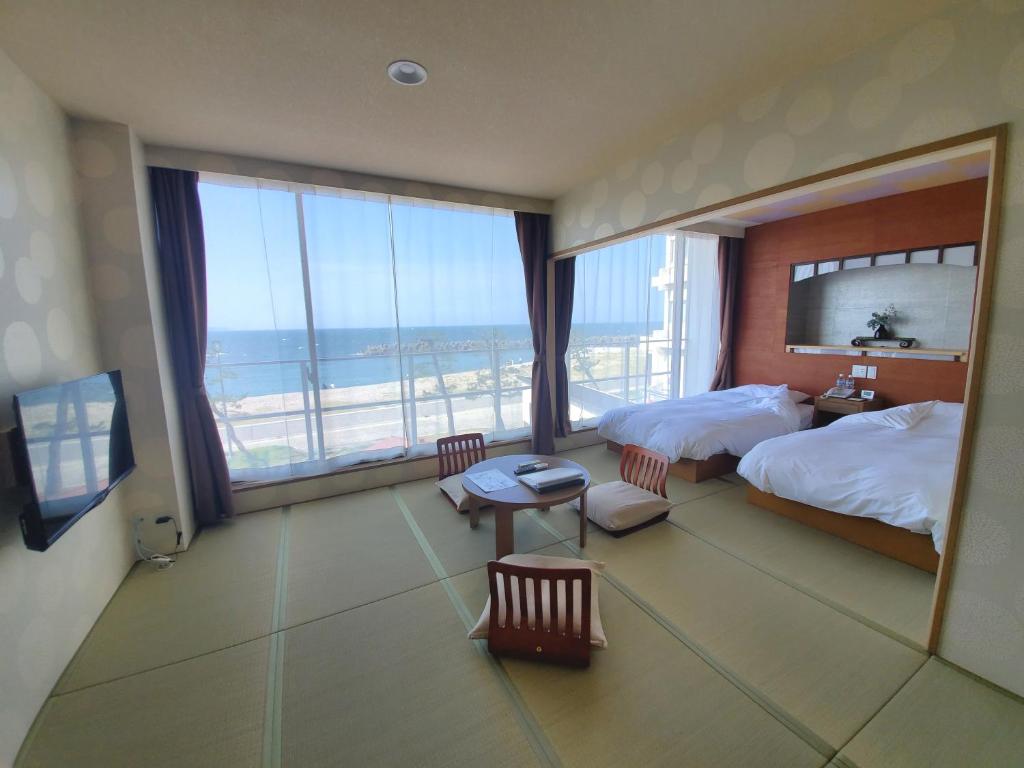 une chambre d'hôtel avec un lit et une grande fenêtre dans l'établissement Bayside Square Kaike Hotel, à Yonago