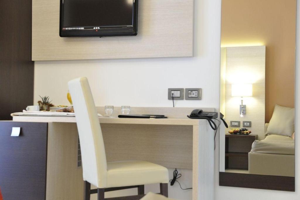 Cette chambre dispose d'un bureau et d'une télévision murale. dans l'établissement Hotel Lido Bibione Beach, à Bibione