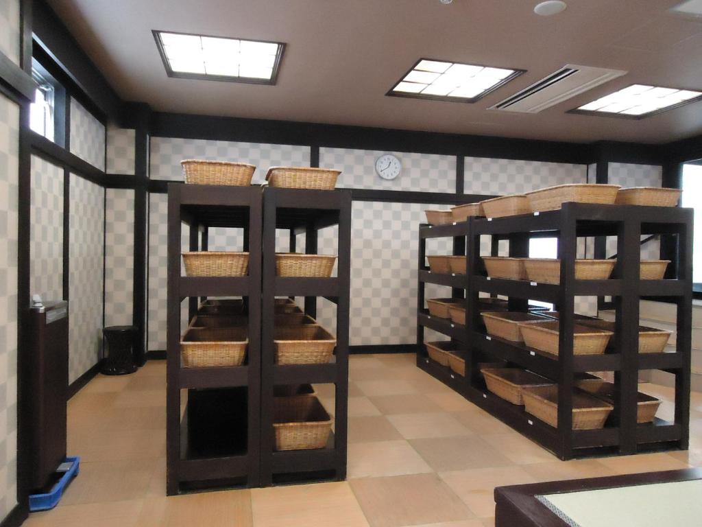 une pièce avec des étagères en bois avec des paniers dessus dans l'établissement Yamagisi Ryokan, à Fujikawaguchiko