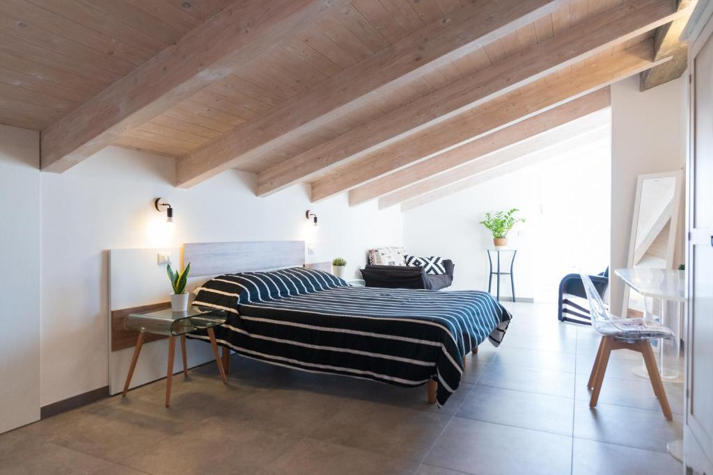 une chambre avec un lit dans une pièce avec des plafonds en bois dans l'établissement Naima Boutique Villa, à Ascea