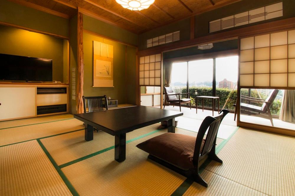 une salle à manger avec une table et des chaises dans une pièce dans l'établissement Yamanoo, à Kanazawa