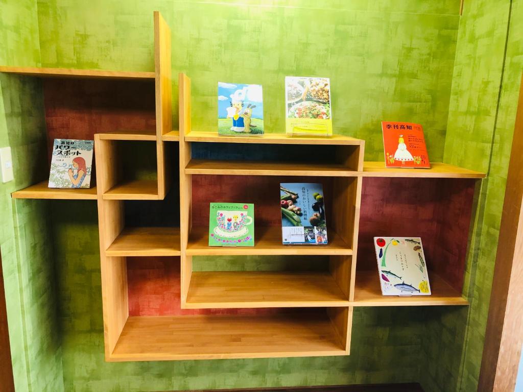 une étagère en bois avec des livres dans l'établissement Hotel Takasago, à Kōchi 37 autres photos