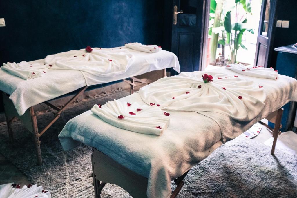 - 2 lits avec des couvertures blanches dans une chambre dans l'établissement Riad Pachavana, à Marrakech
