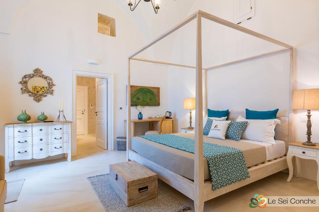 - une chambre dotée d'un lit à baldaquin avec des oreillers bleus et blancs dans l'établissement Le Sei Conche Relais & SPA, à Gemini