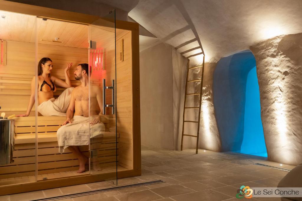 une chambre avec deux hommes et une femme dans un sauna dans l'établissement Le Sei Conche Relais & SPA, à Gemini