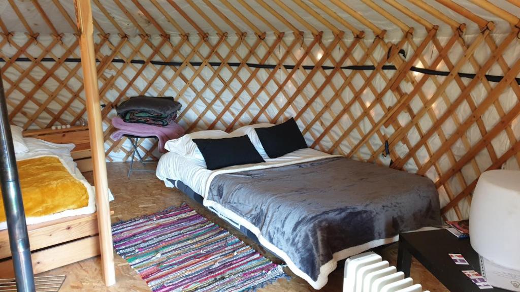 une chambre avec un lit dans une yourte dans l'établissement Yourtes 6 personnes proche provins et disney, à Bannost