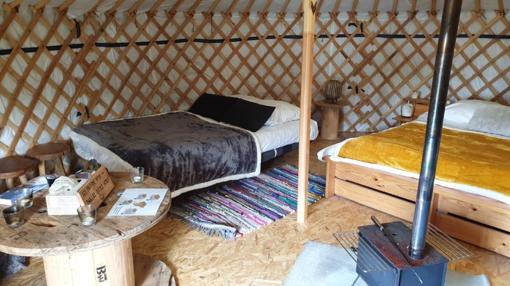 - une chambre avec un lit et une table dans une yourte dans l'établissement Yourtes 6 personnes proche provins et disney, à Bannost