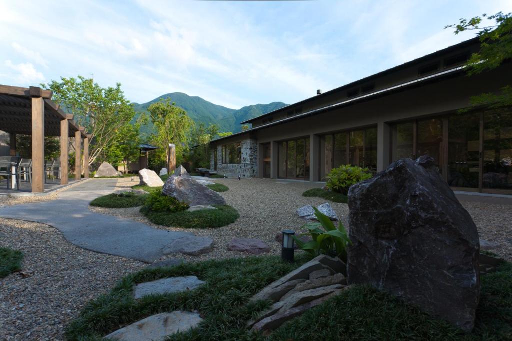 un bâtiment avec des rochers devant une cour dans l'établissement Yufuin Bettei Itsuki, à Yufu