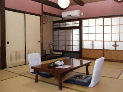 un salon avec une table et des chaises en bois dans l'établissement Syofuso, à Yumura