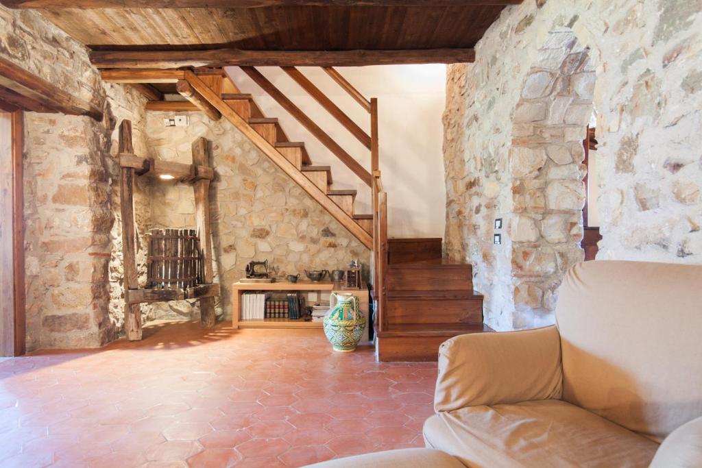 - un salon avec un escalier et un mur en pierre dans l'établissement Relax at the Swimming Pool by Wonderful Italy, à Cefalù