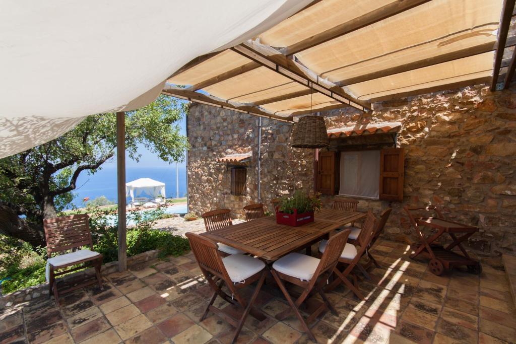 un patio extérieur avec une table et des chaises en bois dans l'établissement Relax at the Swimming Pool by Wonderful Italy, à Cefalù