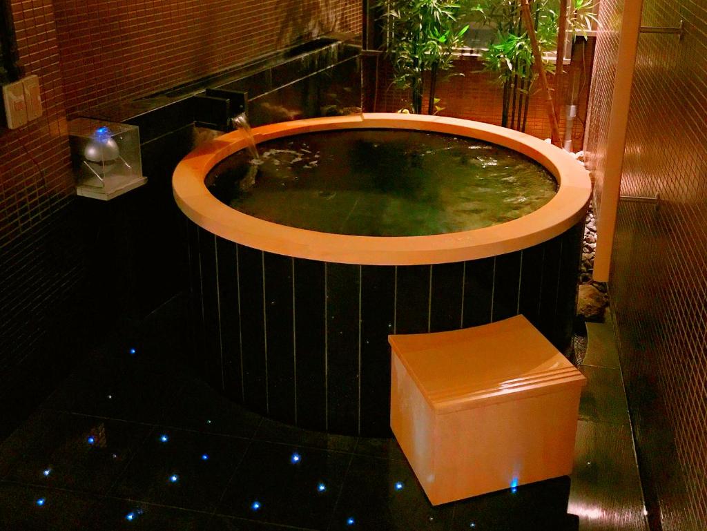 une baignoire jacuzzi avec banc dans une chambre dans l'établissement Ginka, à Toyooka