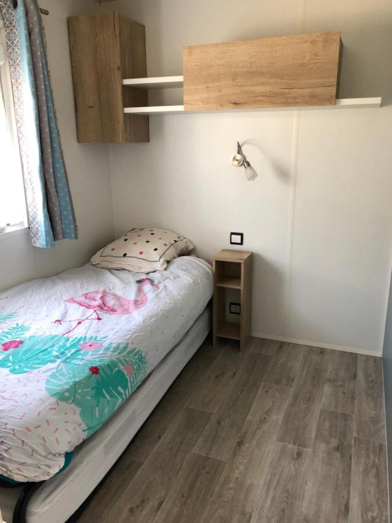- une petite chambre avec un lit et du parquet dans l'établissement Mobile Home - Les Dunes de Contis, à Saint-Julien-en-Born